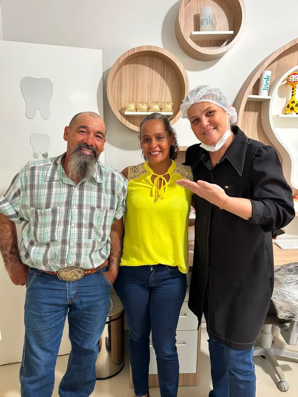 Doutora junto de duas pessoas na clínica
